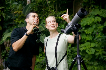 Pretty Woman with Binoculars and Man with Telescope in Jungle